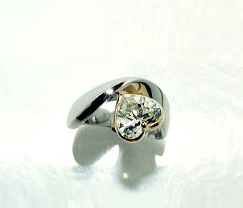 ハートカットのダイヤが印象的なリング。ダイヤ周りはゴールドで。